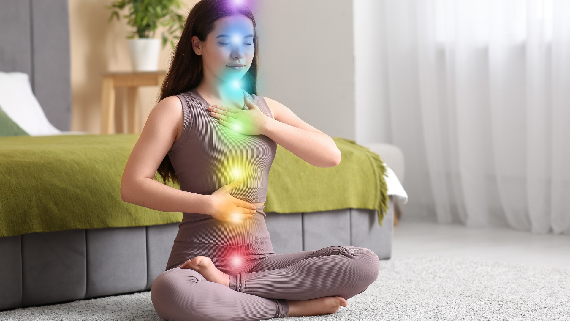 Femme assise en tailleur, mains sur le buste, points d’énergie colorés le long du corps